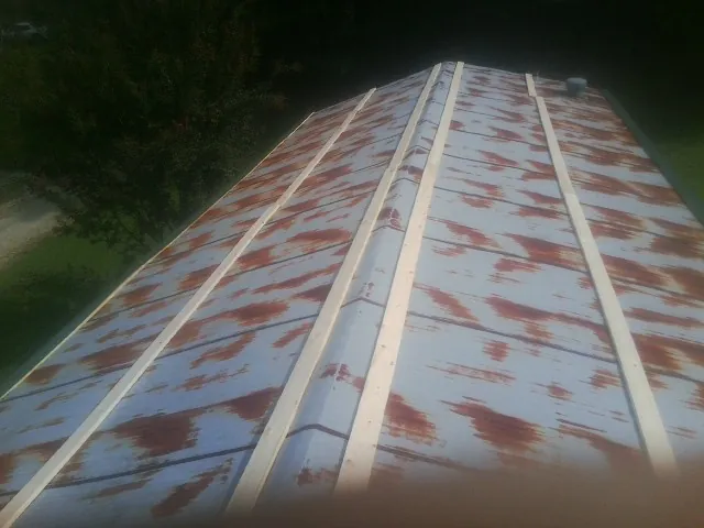 Rusted metal roof panels with new wood purlins before replacement — Storm Damage Roof Repair in Pepperell by Roofing Brothers